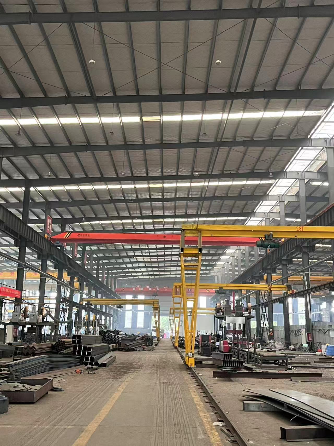 Steel workshop interior with overhead crane handling a large component