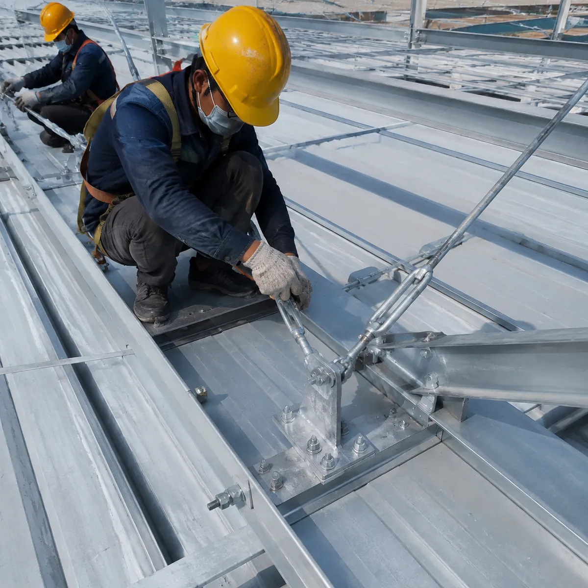 Steel roof bracing and anchor bolts installed on a warehouse frame