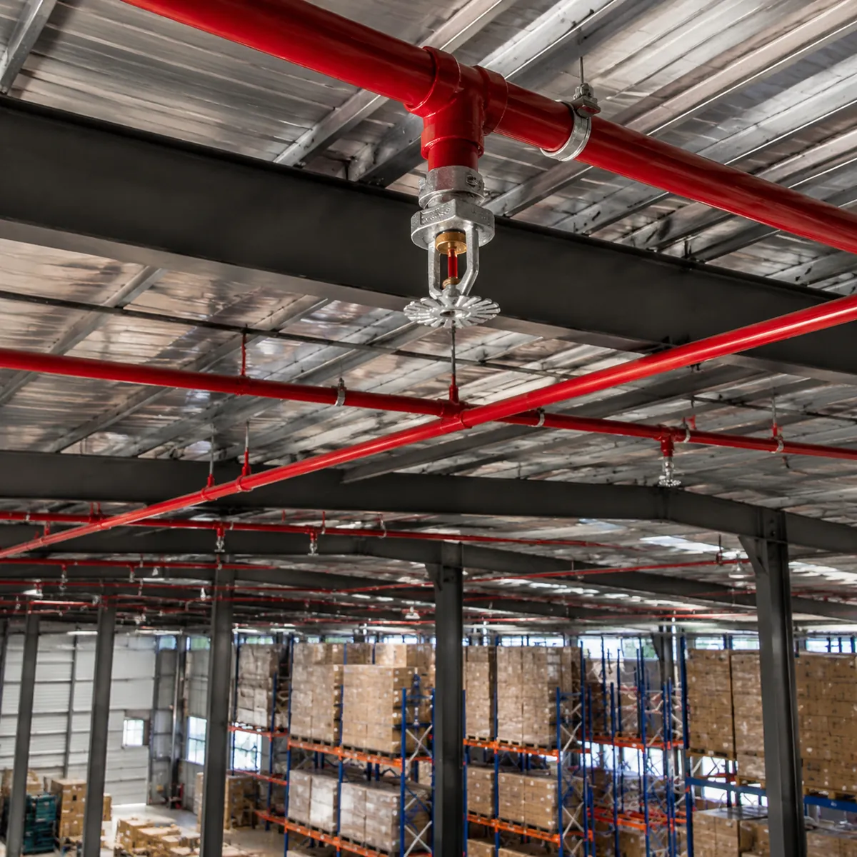 Steel warehouse interior with fire sprinkler system under the roof