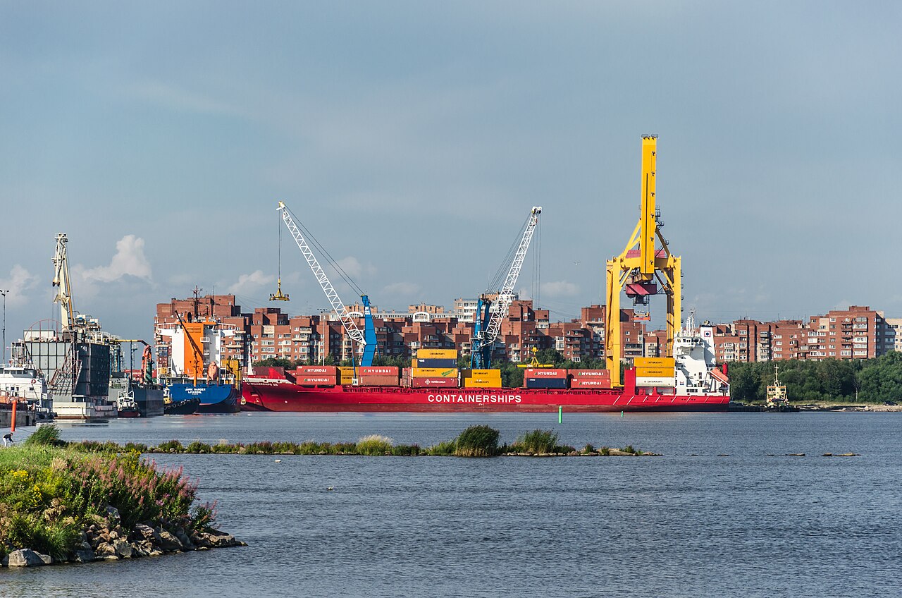 Steel beam bundles lifted by a port crane at a container terminal