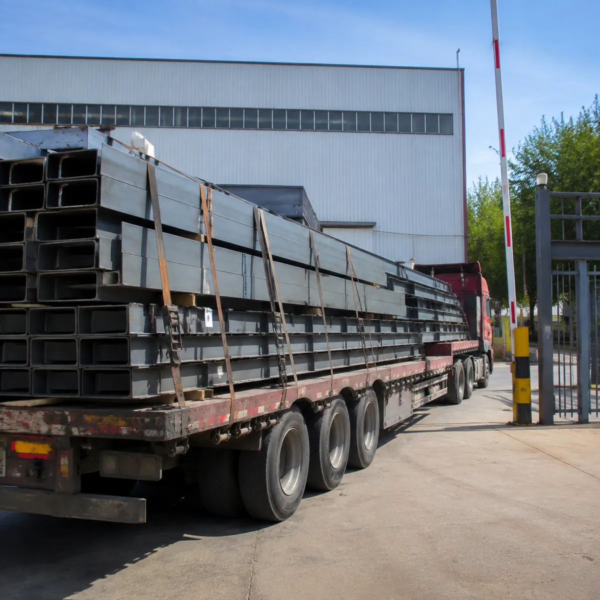 Truck loaded with steel building components leaving the factory