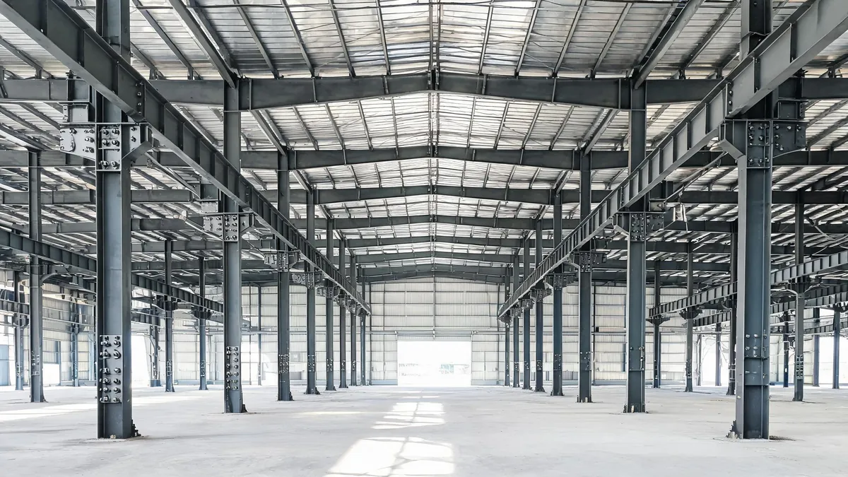 Interior of a newly erected hot rolled steel frame industrial building with bolted end plate connections and crane runway brackets
