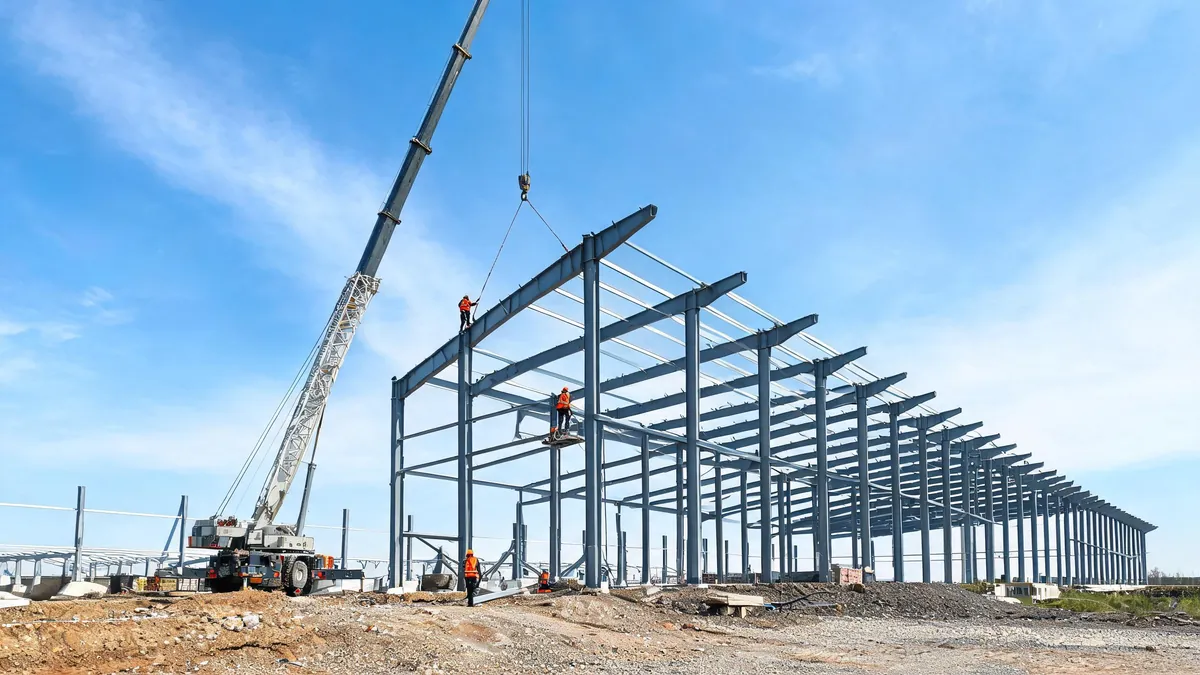 Clear span steel portal frame warehouse under erection with columns, rafters and purlins